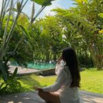 Jeune fille sur un tapis de yoga dans la nature