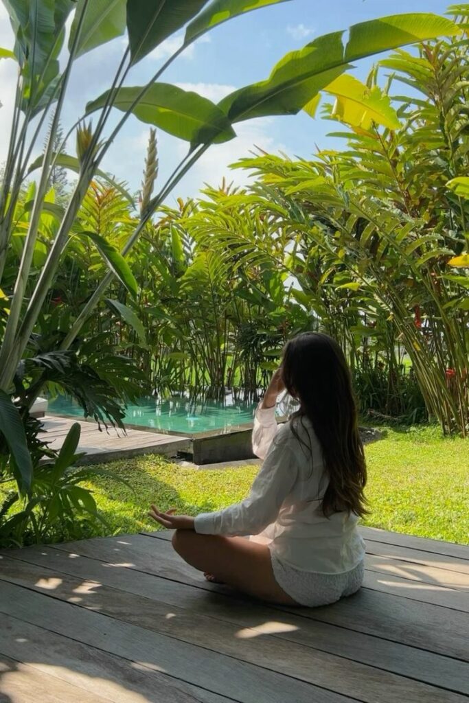 Jeune fille sur un tapis de yoga dans la nature