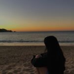 Fille à la plage regardant la mer