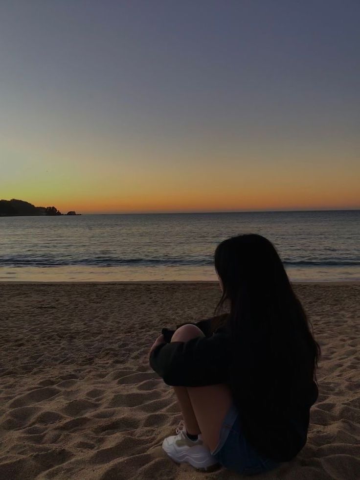 Fille à la plage regardant la mer